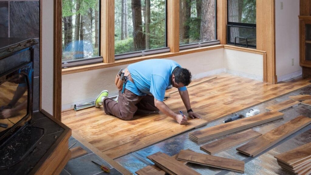 Installer laying wood floor planks